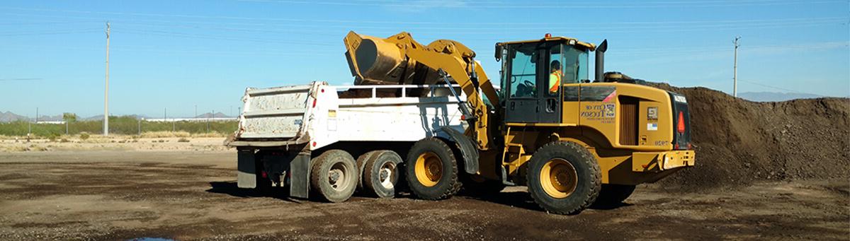 A Large front loader works in an empty lot in Tucson